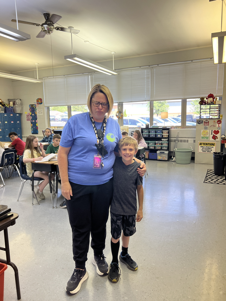 Teacher and student posing in a classroom.