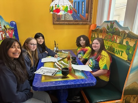 Students sitting together at a restaurant booth.