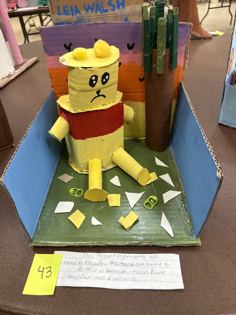Recycled art project showing a bear beside a tree.
