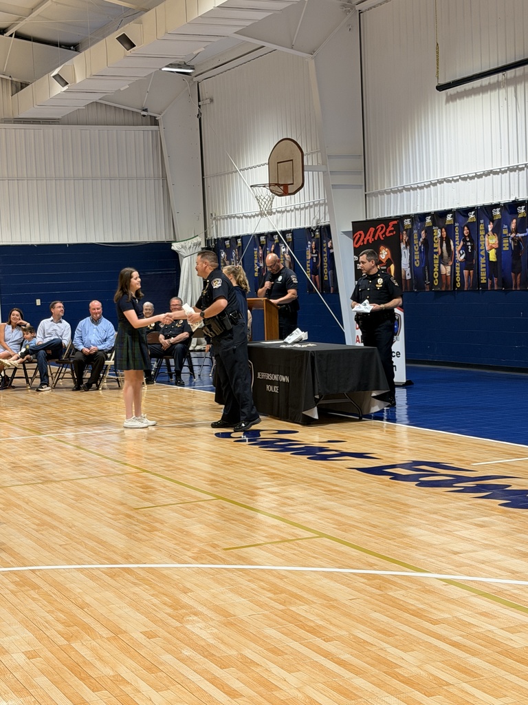 Student shaking hands with an officer at D.A.R.E. graduation.