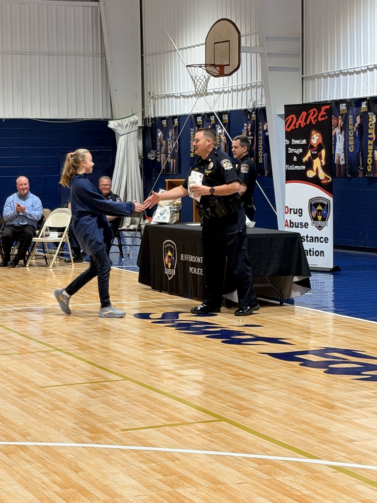 Student shaking hands with an officer at D.A.R.E. graduation.