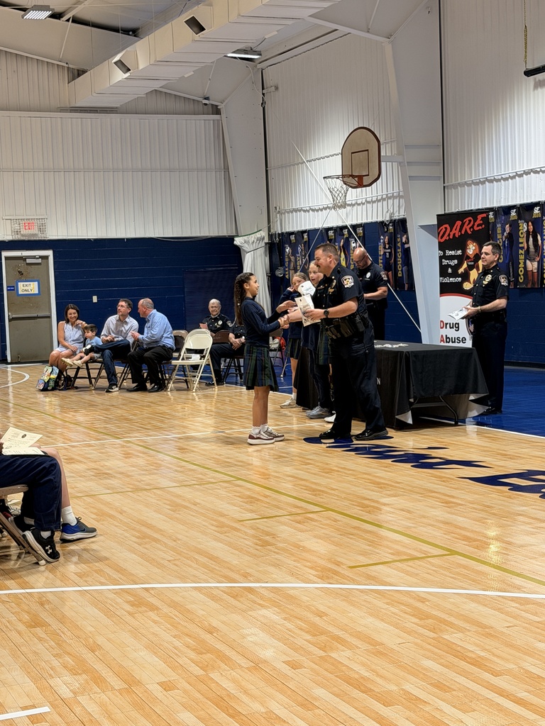 Student shaking hands with an officer at D.A.R.E. graduation.