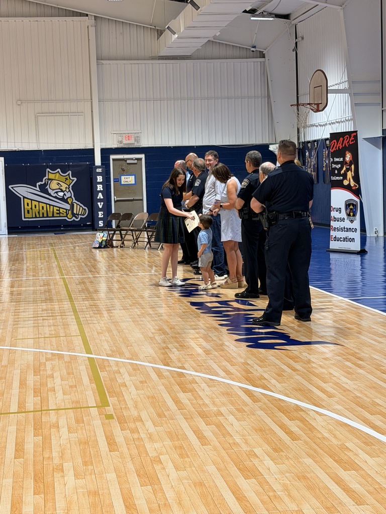 Student receiving a certificate on the gym floor.