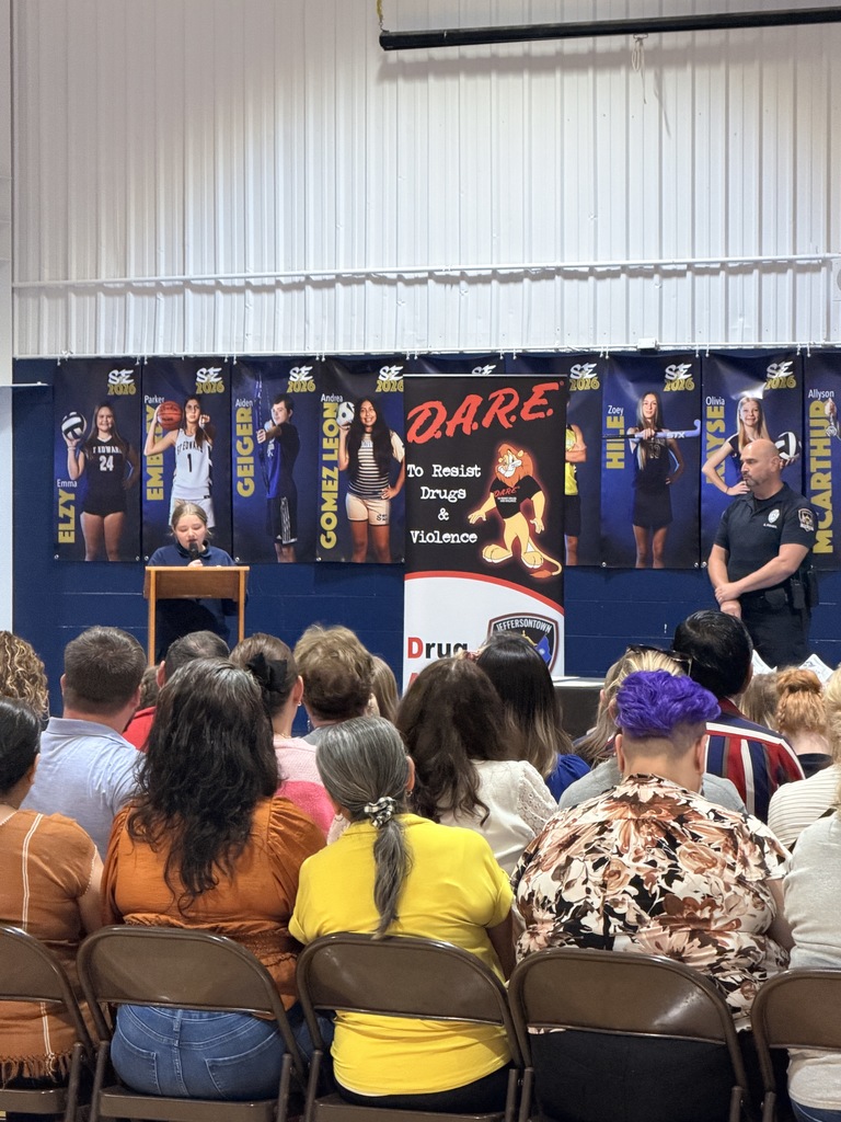 Families and students seated in the gym for D.A.R.E. graduation.
