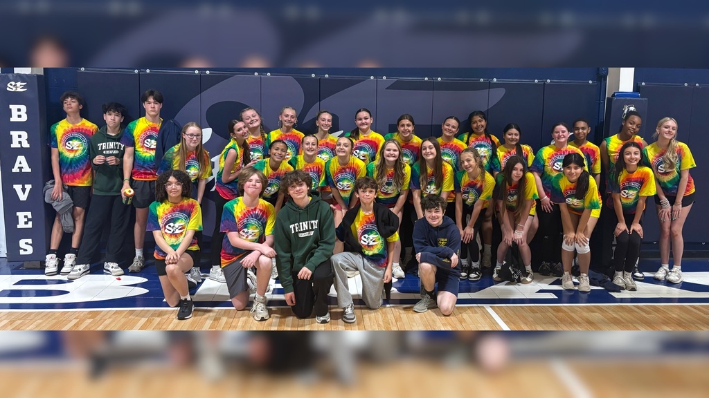 Eighth grade class posing together in the gym.