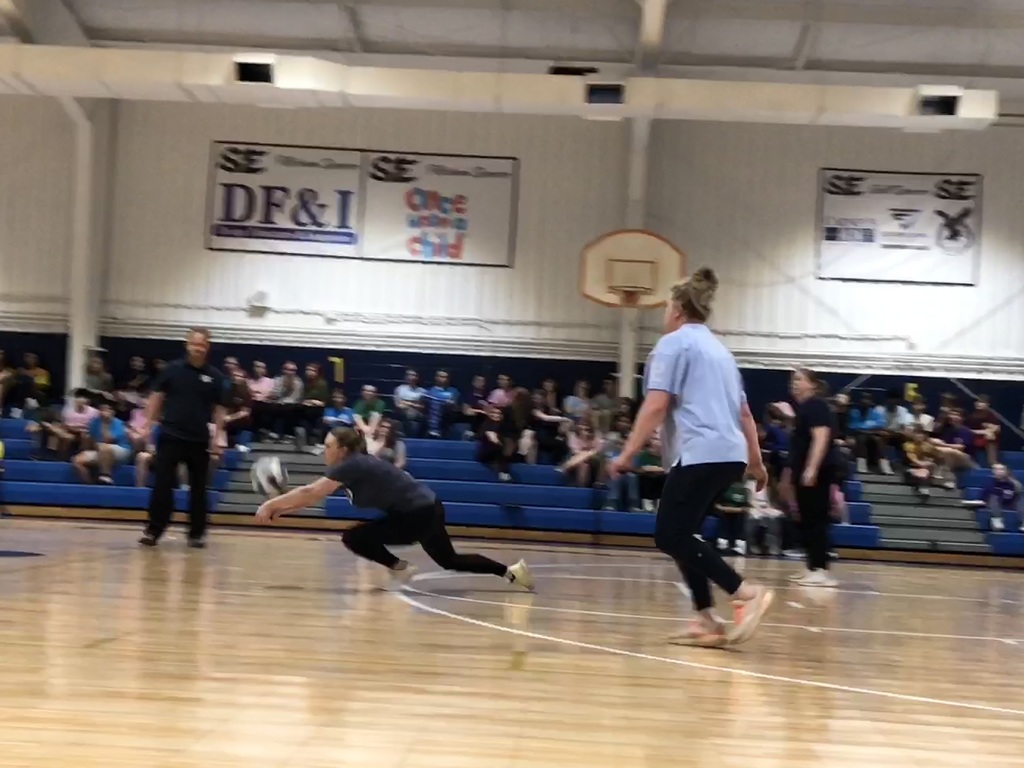Faculty player diving for the ball during the volleyball game.