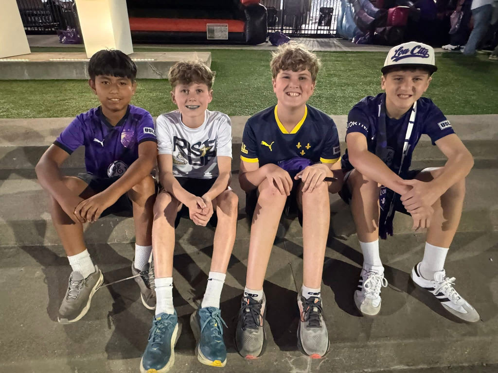 Four boys sitting together in LouCity gear after the game.