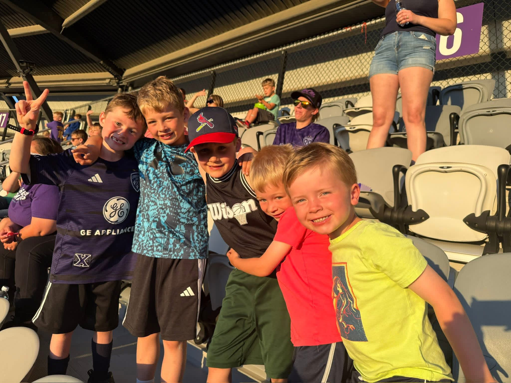 Five boys posing together in the stands during the LouCity game.