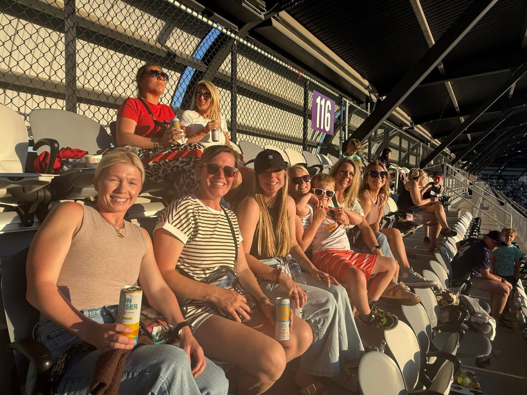 St. Edward mothers sitting together in the stands at a LouCity soccer game.