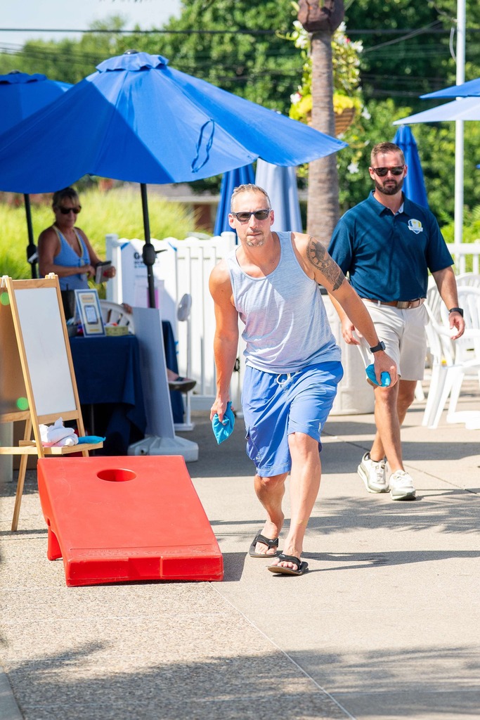 adult playing corn hole