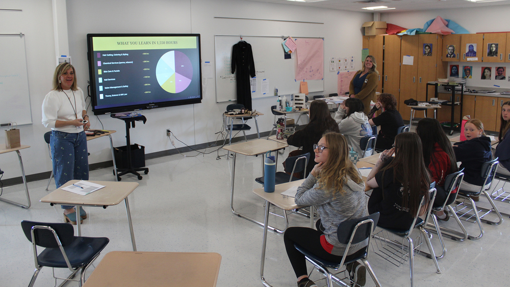 presenters at the front of a classroom full of students