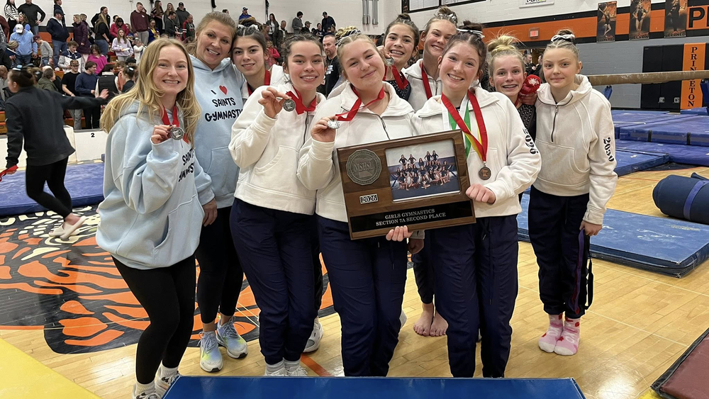 gymnastics team posing with 2nd place section trophy