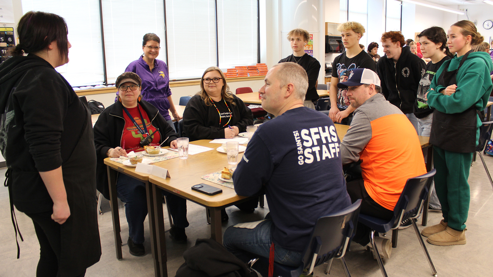 students and judges at a table