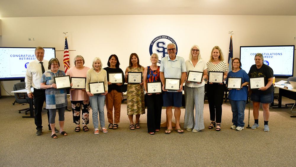 lineup of retirees holding certificates with Supt Anderson