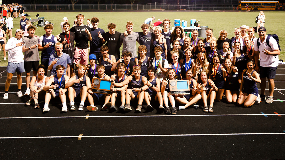 boys and girls track and field teams posing for a photo on the track