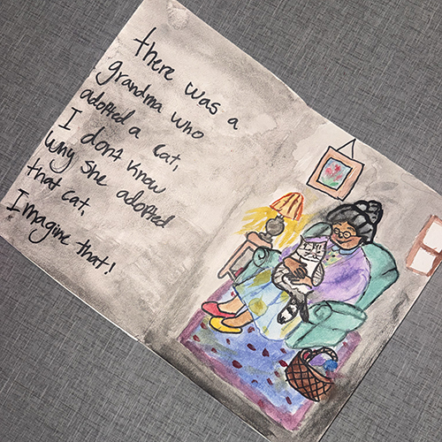 book open to a page written and illustrated by a Saints Academy student