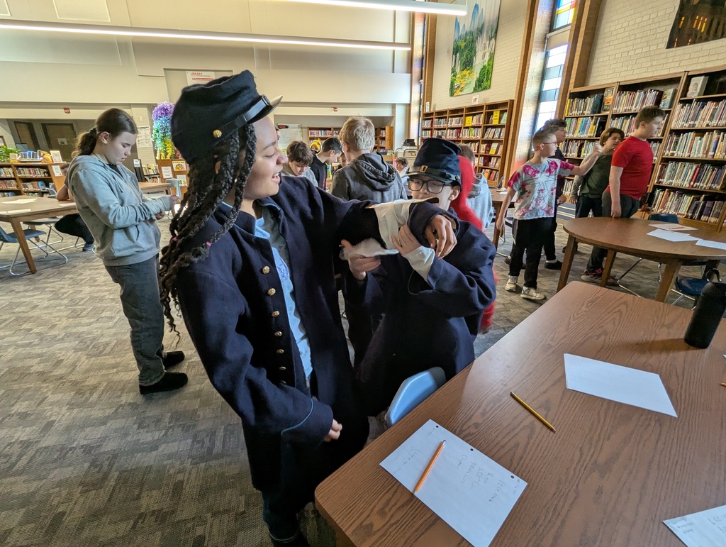 Students practice wrapping a Civil War arm splint. 