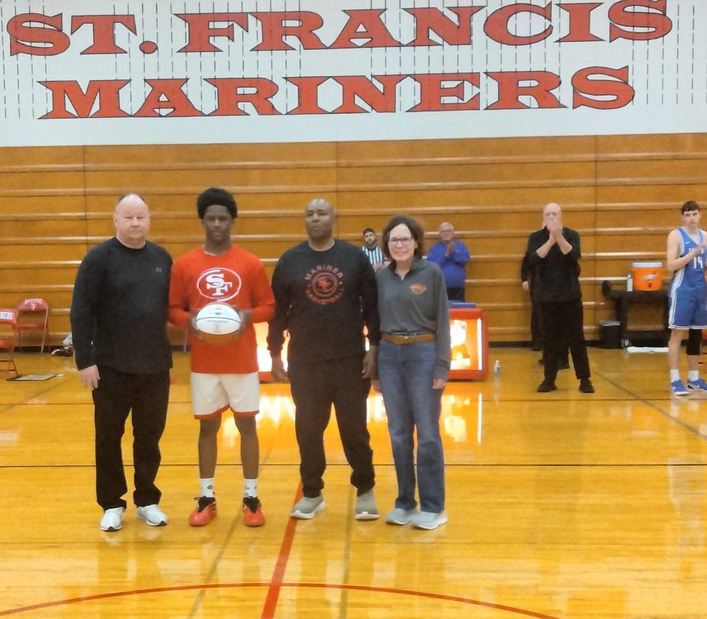 Basketball Player with coaches and parents holding his 1000 point basketball