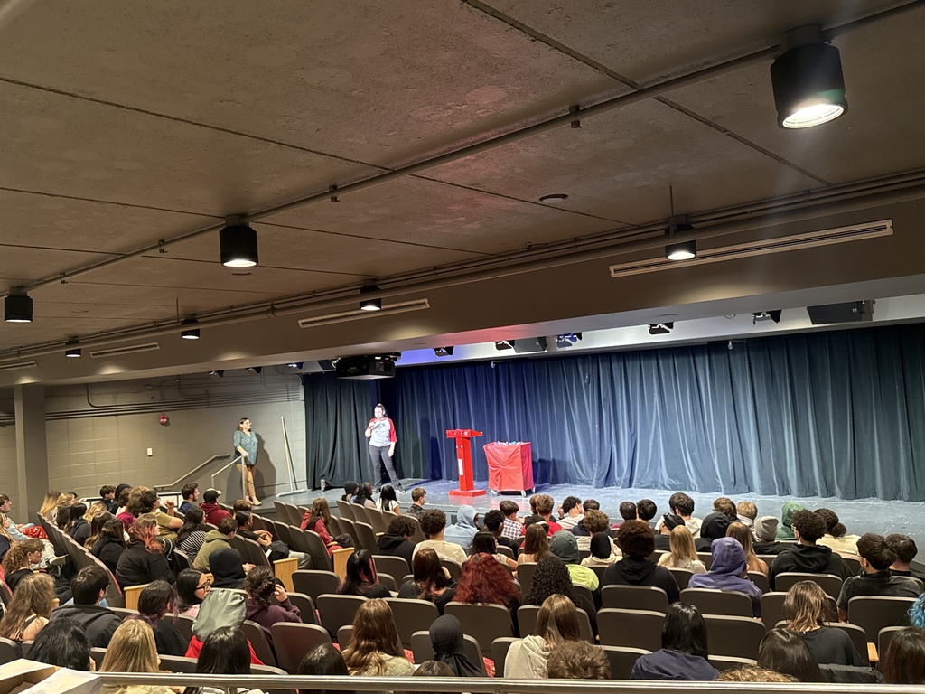 Students sit in the auditorium as winners are announced on the stage.