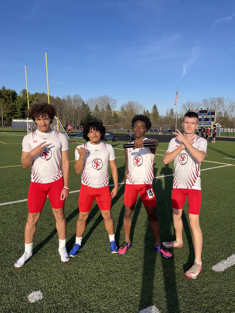 Track runners stand on the field after setting the school record. 