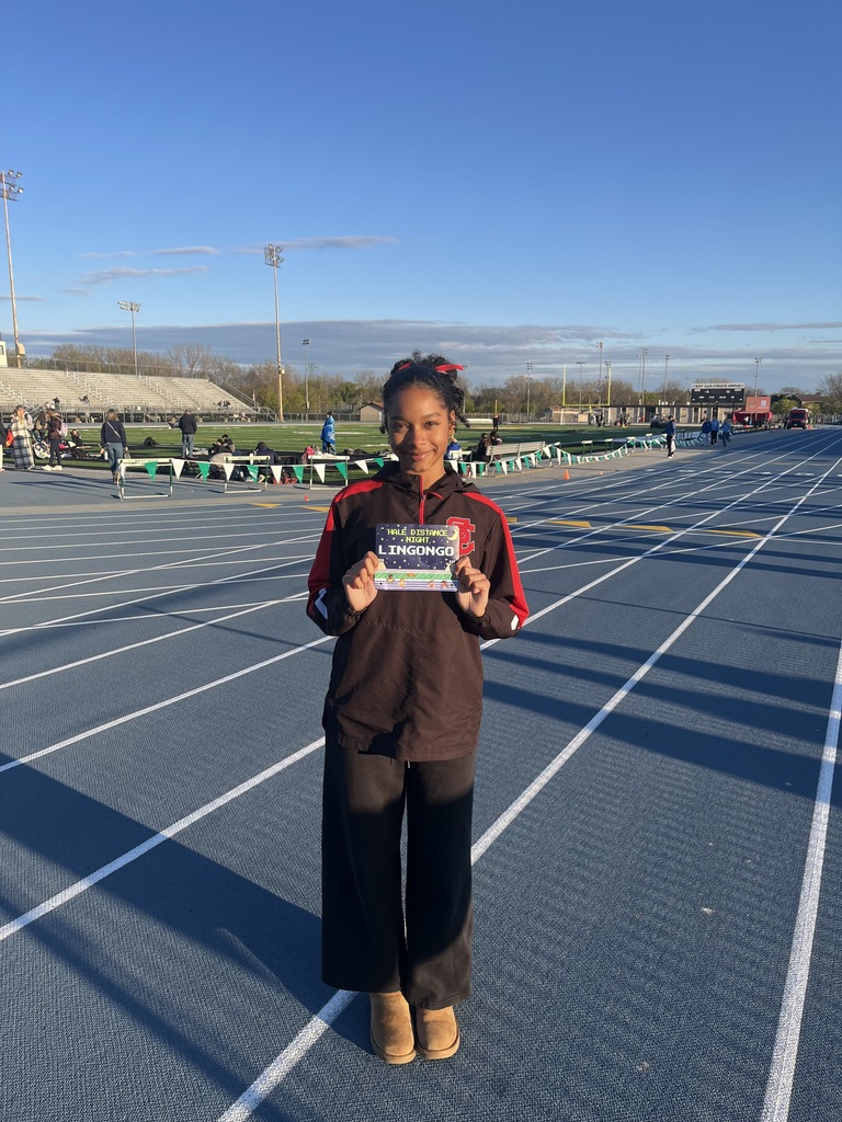 Emma is standing on the track with her certificate. 