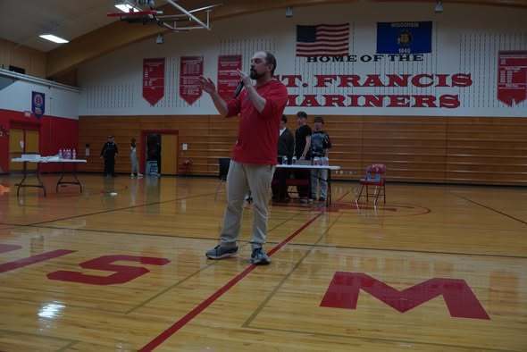 Teacher emceeing the assembly in the gym