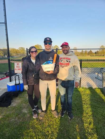Senior Night baseball with a senior and his parents behind the bench