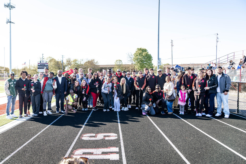 Track seniors and their family stand on the track. 