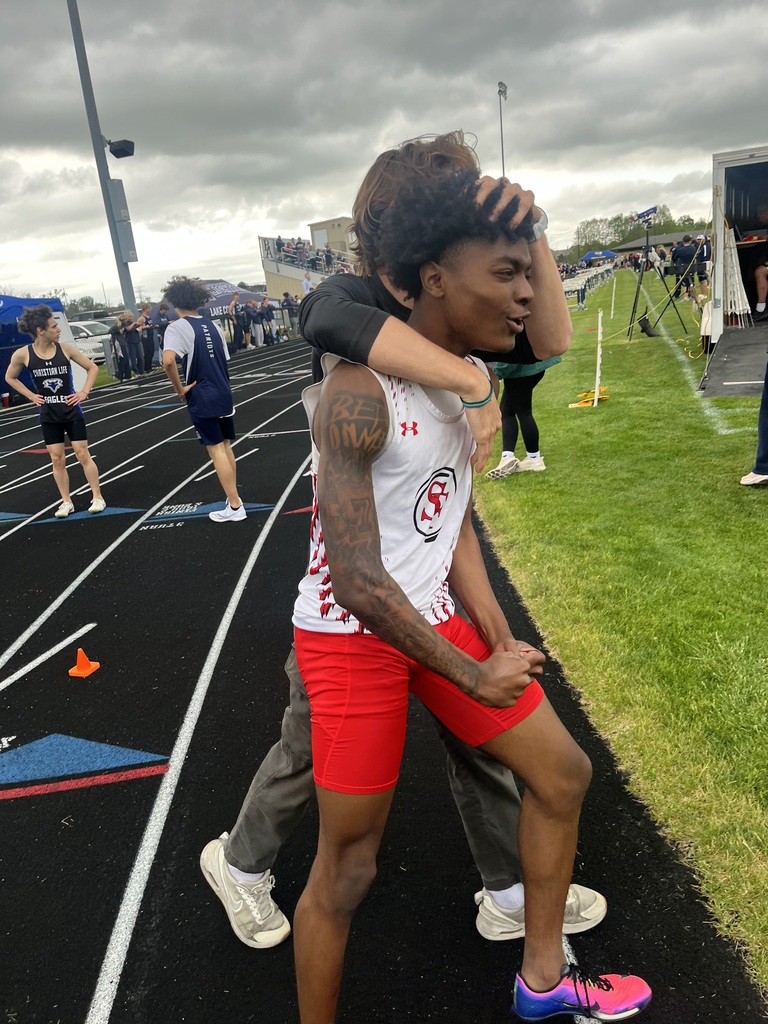 Track runner being hugged after breaking the record on the track. 