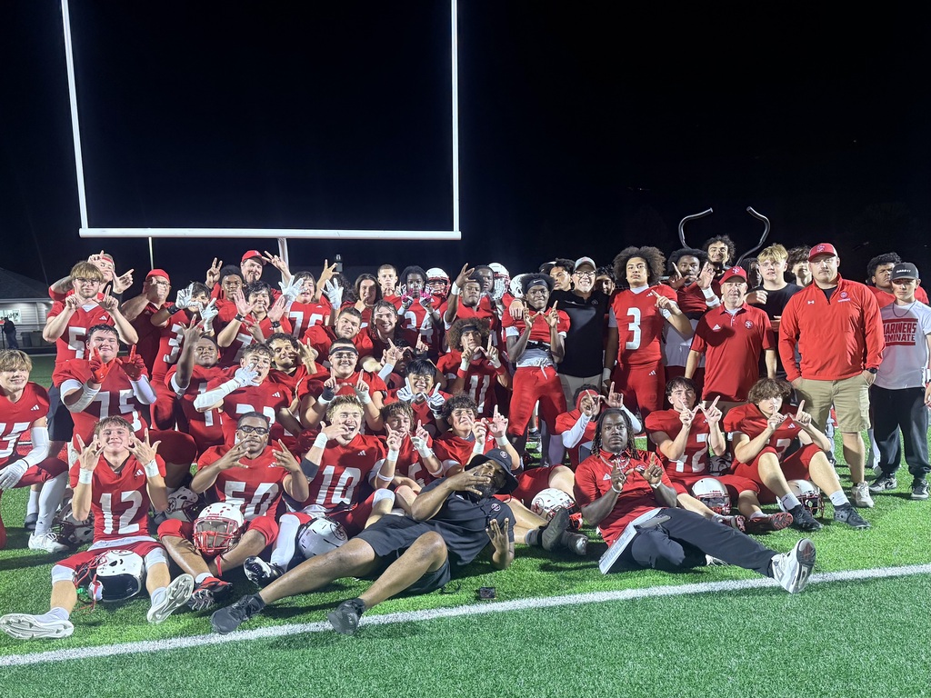 Football team making W with their hands on the field.