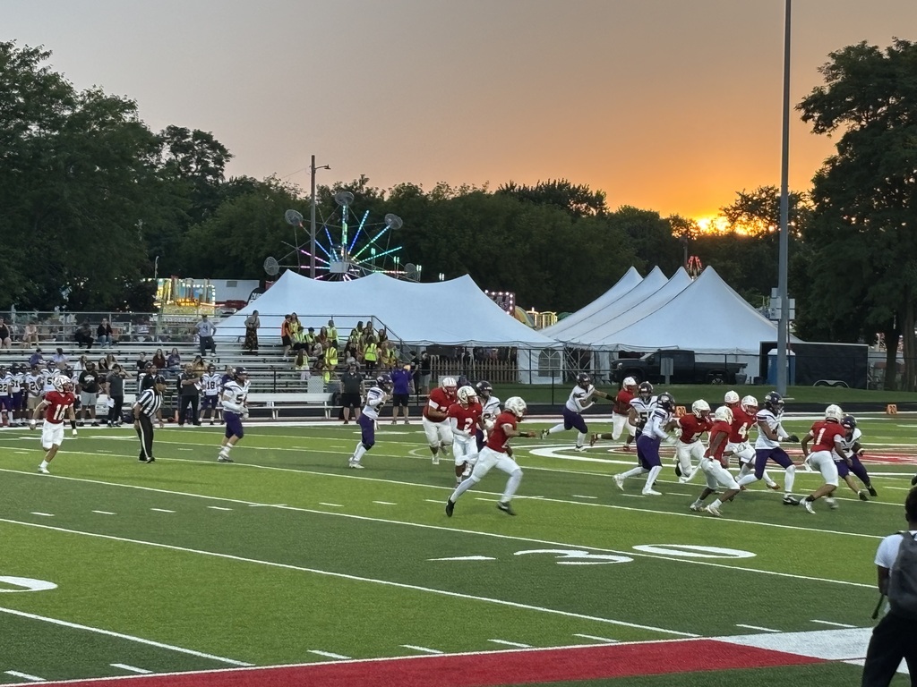 Football game with a sunset in the background.