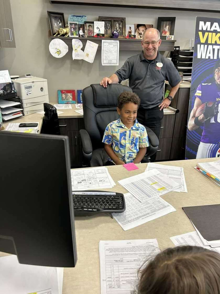 child standing behind desk