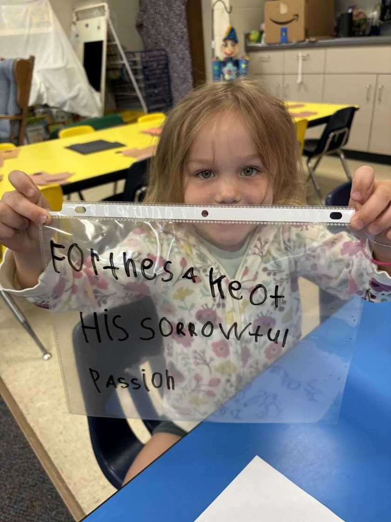 child writing prayer on sheet protector
