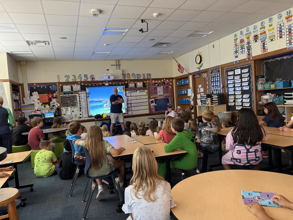 Parent addressing students about fire safety prior to putting on his fire fighting gear.