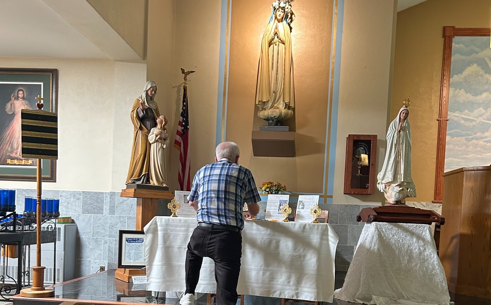 man kneeling before relics