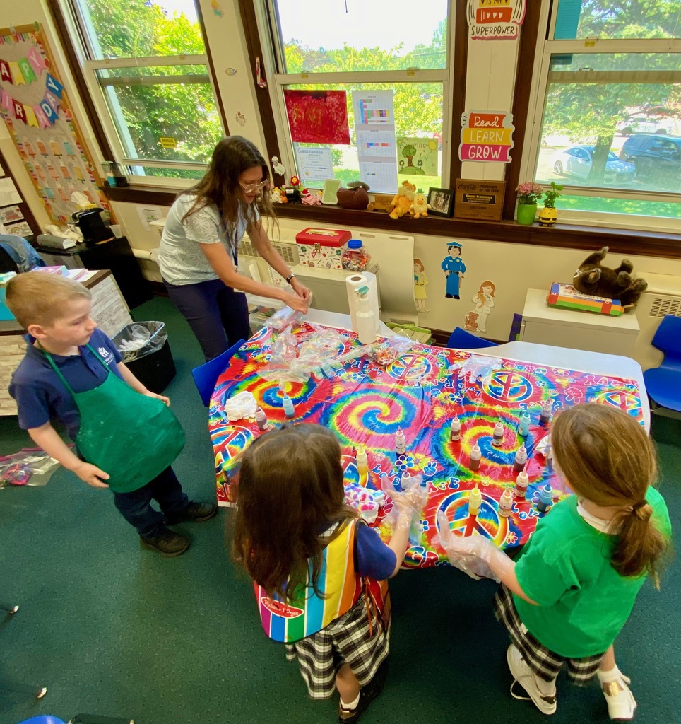 Grade 1 students dye tie-dye t-shirts in their classroom