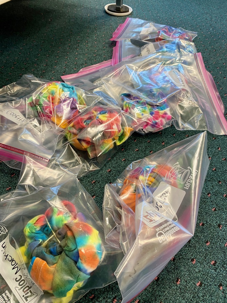 Grade 1 students dye tie-dye t-shirts in their classroom