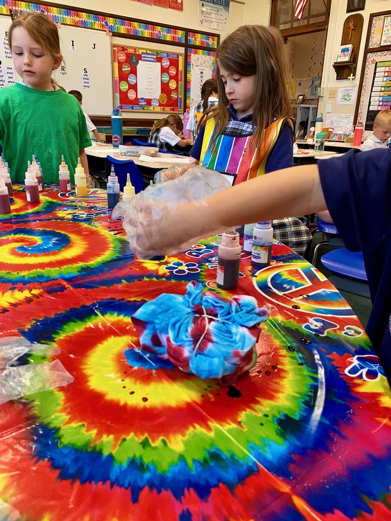 Grade 1 students dye tie-dye t-shirts in their classroom