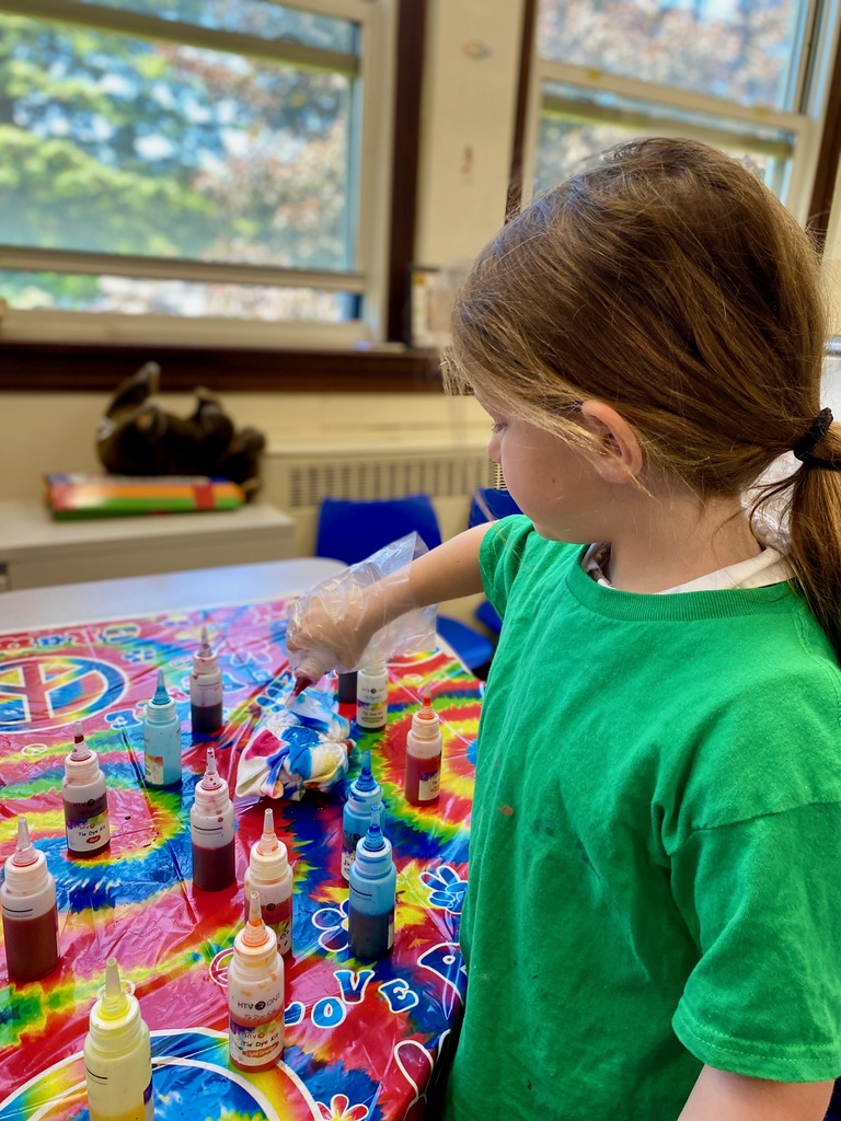 Grade 1 students dye tie-dye t-shirts in their classroom
