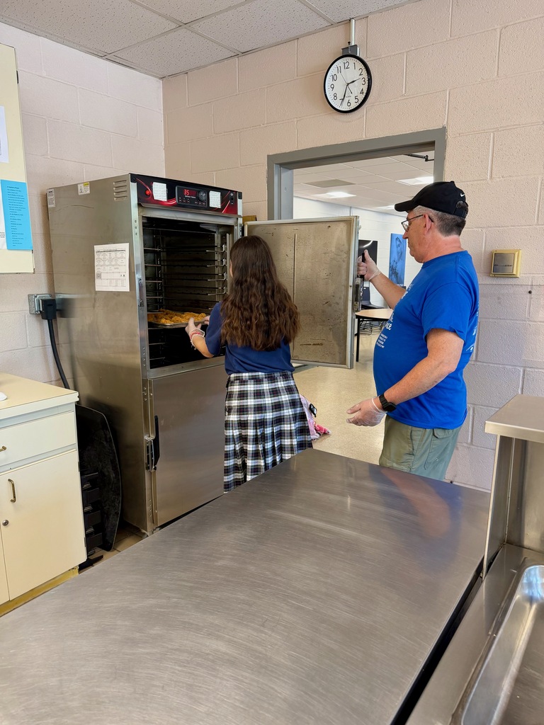 Student preparing chicken fingers in the school cafeteria