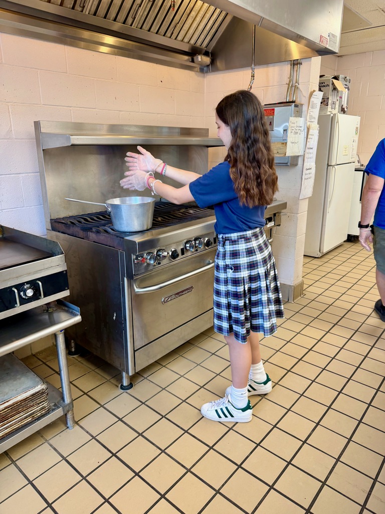 Student preparing buttered noodles in the school cafeteria