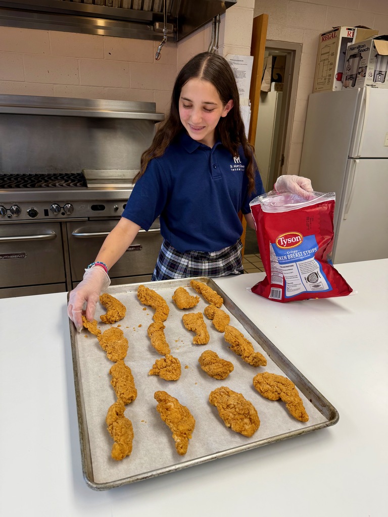 Student preparing chicken fingers in the school cafeteria