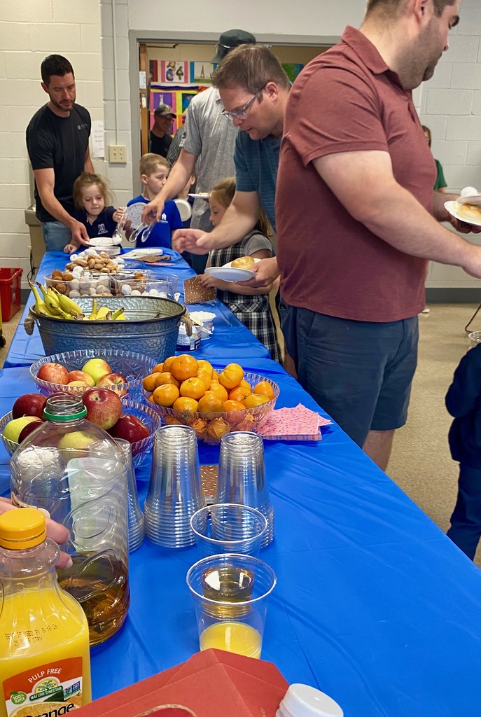 SMS students posing with their dads or grandpas at Donuts with Dads