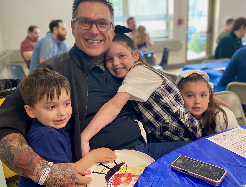 SMS students posing with their dads or grandpas at Donuts with Dads