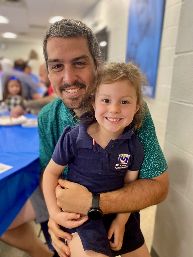 SMS students posing with their dads or grandpas at Donuts with Dads