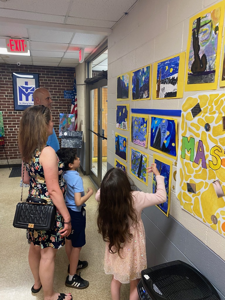 Family viewing artwork hung in the hallway