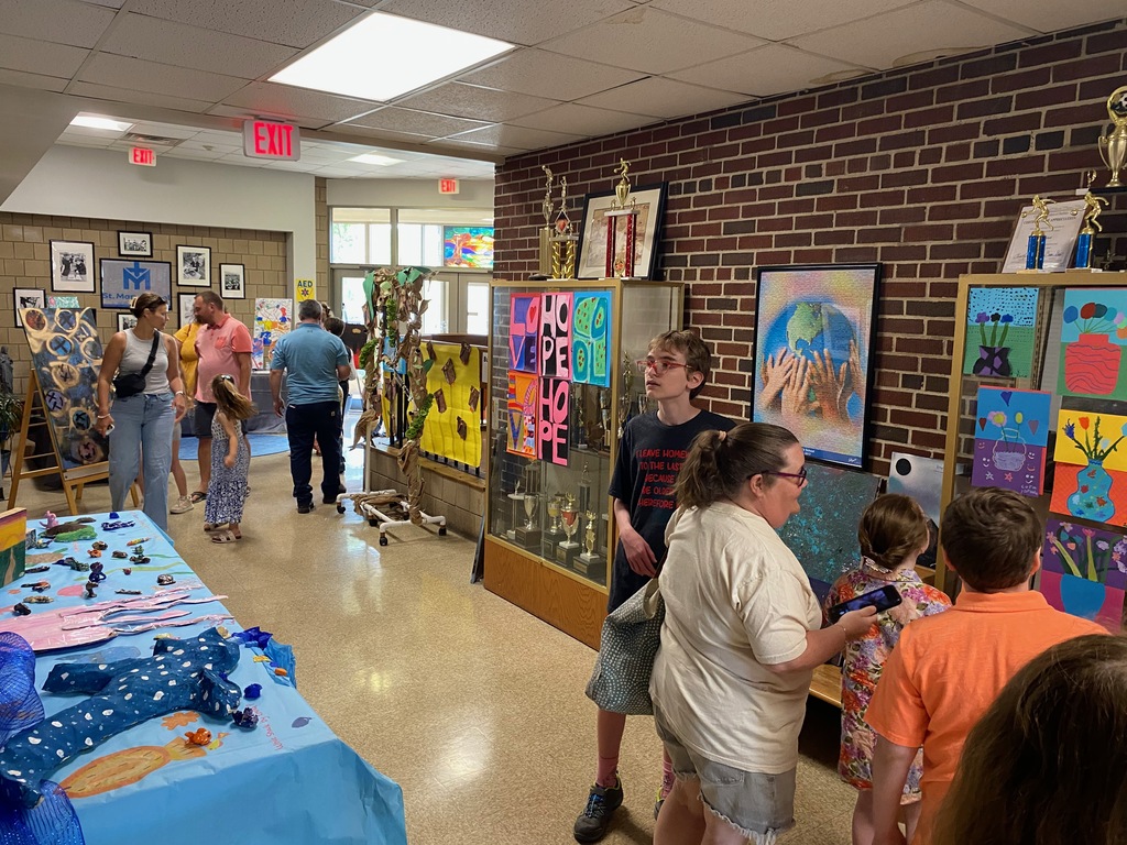 Families viewing artwork displayed in the hallways