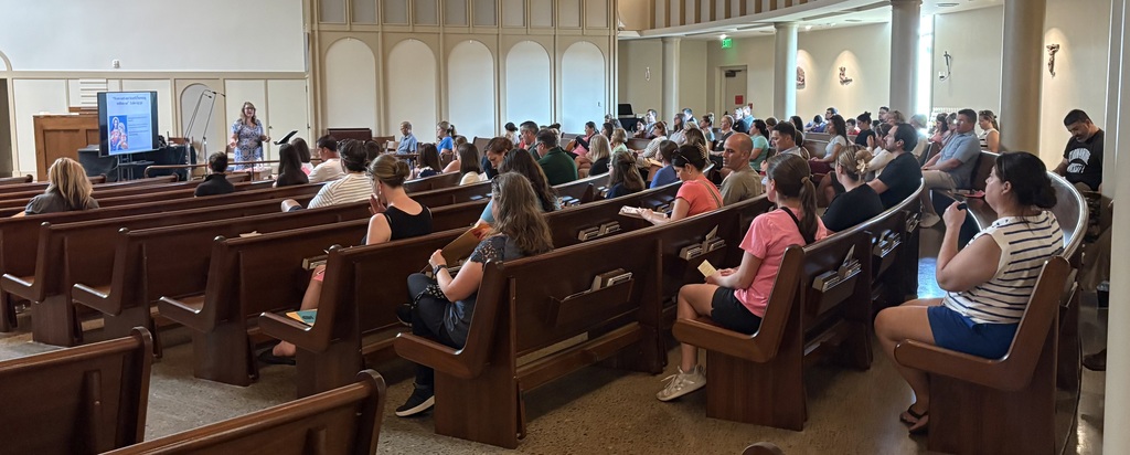 parents at meeting in church pews
