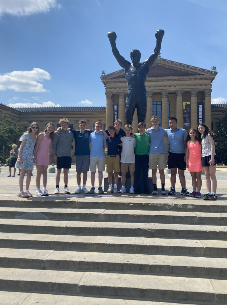 Photos from the 8th grade class trip featuring the whole class in front of Philadelphia landmarks