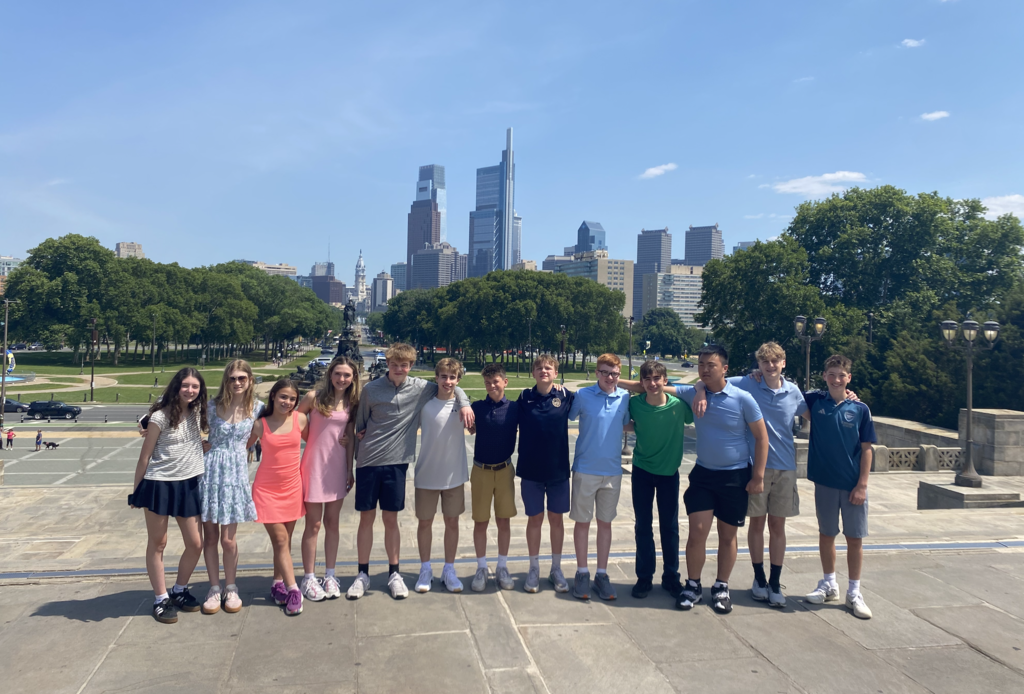 Photos from the 8th grade class trip featuring the whole class in front of Philadelphia landmarks